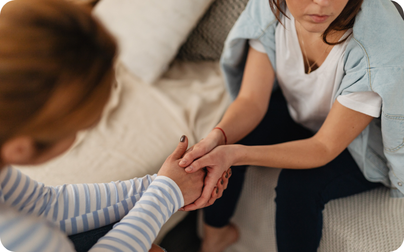 Supportively holding the hand of someone at our eating disorder treatment clinic in Somerset, UK.